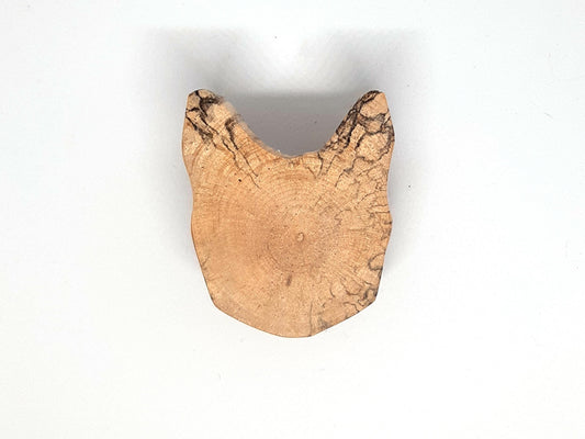 Paire de poignées en bois massif en forme de tête de chat, sculptées à partir de rondins de bois naturel avec leurs cernes visibles. Sur des portes blanches, elles apportent une touche artisanale et originale au mobilier. Fabrication artisanale