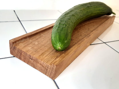Planche à découper réversible en bois massif, avec côté classique et côté à rebords, inspiré de la recette de concombre de Lena Situations. Idéale pour découper légumes, saucisson ou pain avec précision. Accessoire de cuisine artisanal et design.