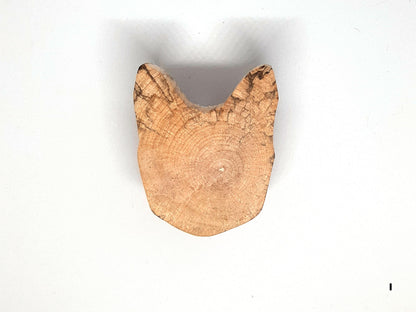 Paire de poignées en bois massif en forme de tête de chat, sculptées à partir de rondins de bois naturel avec leurs cernes visibles. Sur des portes blanches, elles apportent une touche artisanale et originale au mobilier. Fabrication artisanale