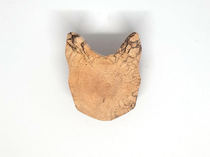 Paire de poignées en bois massif en forme de tête de chat, sculptées à partir de rondins de bois naturel avec leurs cernes visibles. Sur des portes blanches, elles apportent une touche artisanale et originale au mobilier. Fabrication artisanale