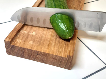 Planche à découper réversible en bois massif, avec côté classique et côté à rebords, inspiré de la recette de concombre de Lena Situations. Idéale pour découper légumes, saucisson ou pain avec précision. Accessoire de cuisine artisanal et design.