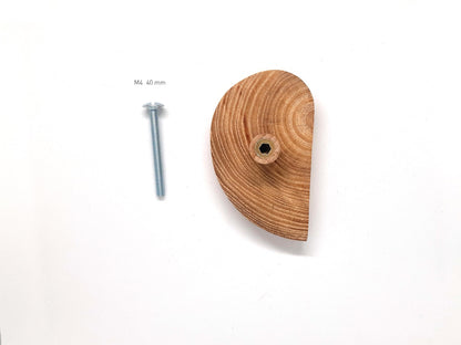 Image de deux poignées en bois naturel, sculptées en demi-cercles et installées sur des portes blanches côte à côte. L’effet miroir entre les deux poignées crée un cercle complet, ajoutant une touche design et graphique à un meuble minimaliste. Cette photo illustre une tendance déco éco-responsable, idéale pour optimiser l’agencement d’espaces contemporains. Mot-clés : poignée bois, meuble design, décoration épurée.